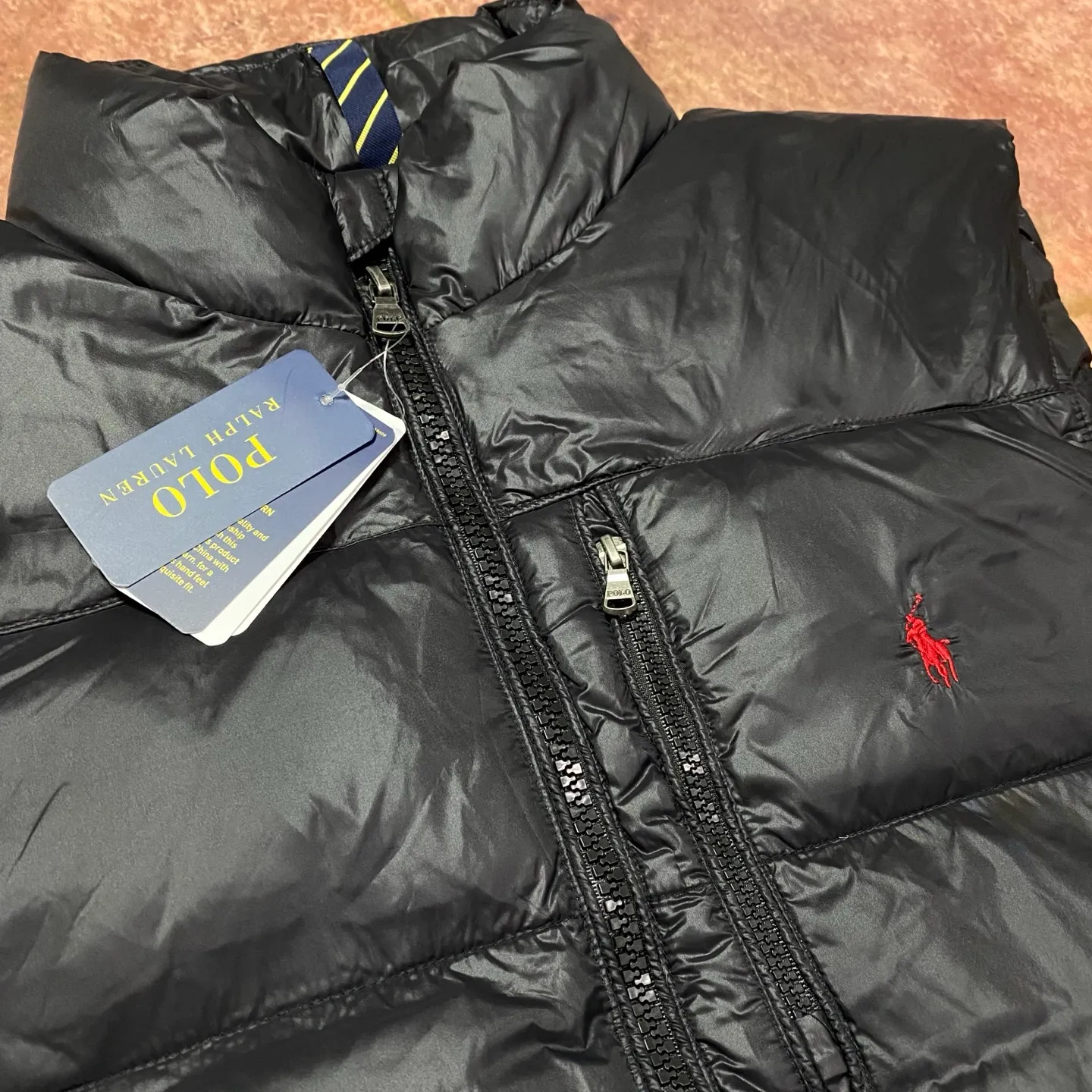 P560 Rah Lauren embroidered down vest (top version of pure down) 100% pure down, a classic and evergreen style, the same model used by celebrities and internet celebrities to keep out the cold, made from fabrics, fillings to auxiliary materials, all-round benchmarking against the original quality. It uses an imported Behringer embroidery machine, 10,000-needle electric embroidery technology, and imported No. 7 needles and embroidery thread to create a full, three-dimensional, clear-textured polo logo on the chest, which can be called a "moving texture badge." Double-layer locked velvet interior, bid farewell to the worry of velvet running away. The inner lining adopts a nylon double-layer sealed velvet structure to strictly prevent velvet drilling. The hem has a built-in adjustable drawstring, making it more windproof and cold-proof. Paired with customized size 8 YKK zipper, a must-have item for autumn and winter. Color Black, Navy Blue, Black Glossy Size m-xxl